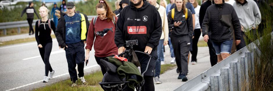 March mod ensomhed - en gruppe mennesker, mest unge, går på en vej