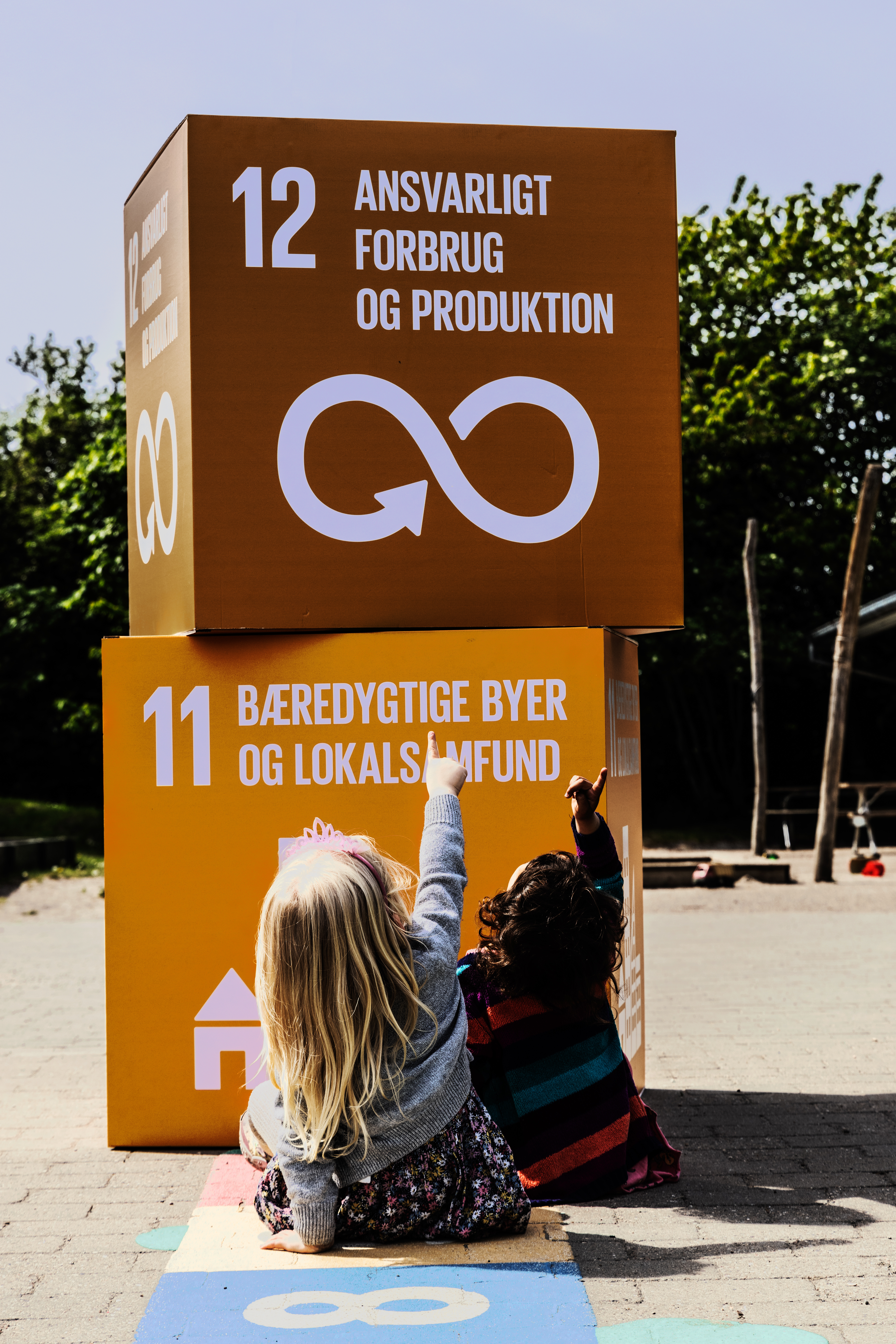 Børn peger på kasser med verdensmålene