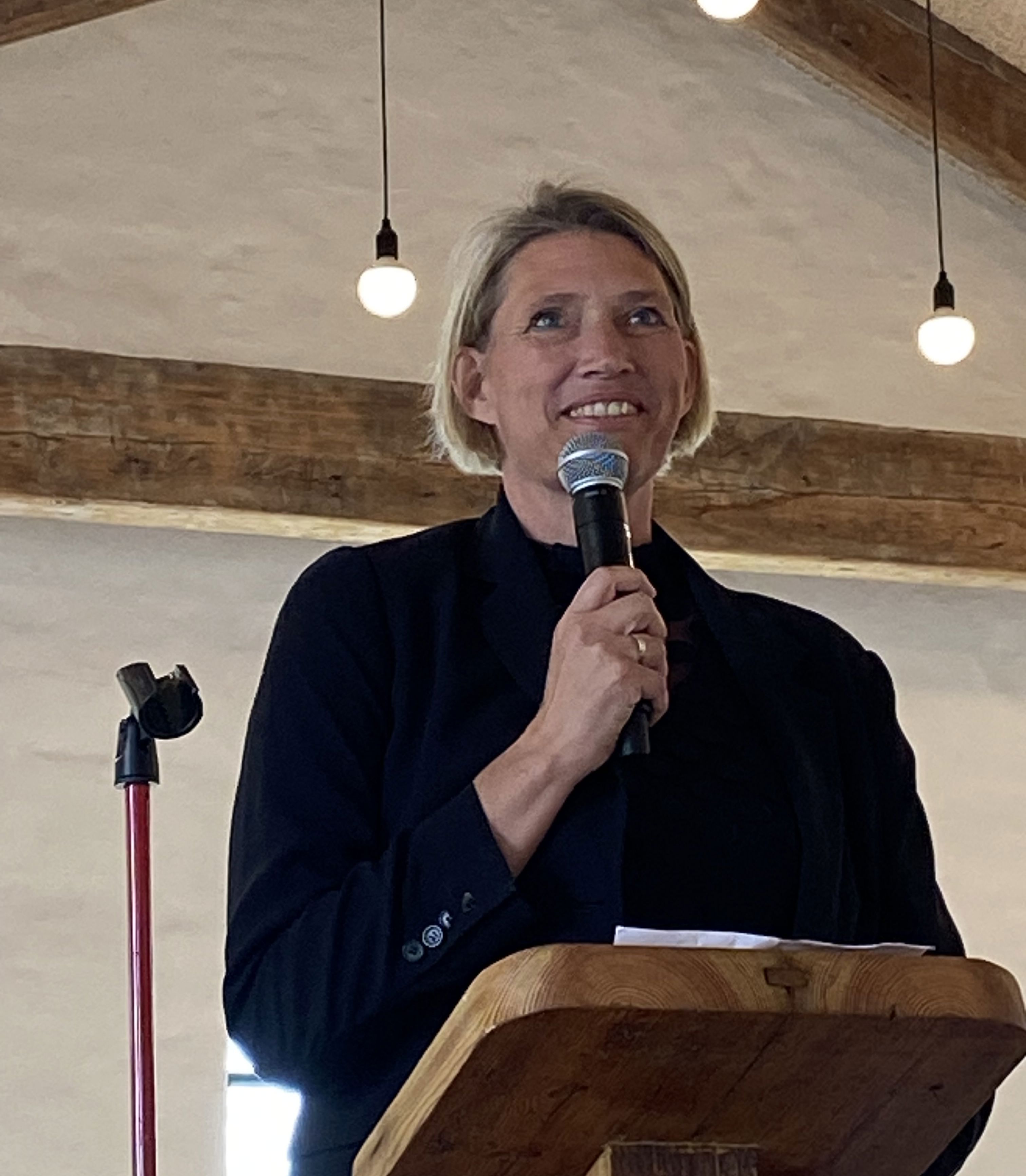 Kvinde står på talerstol og taler i mikrofon