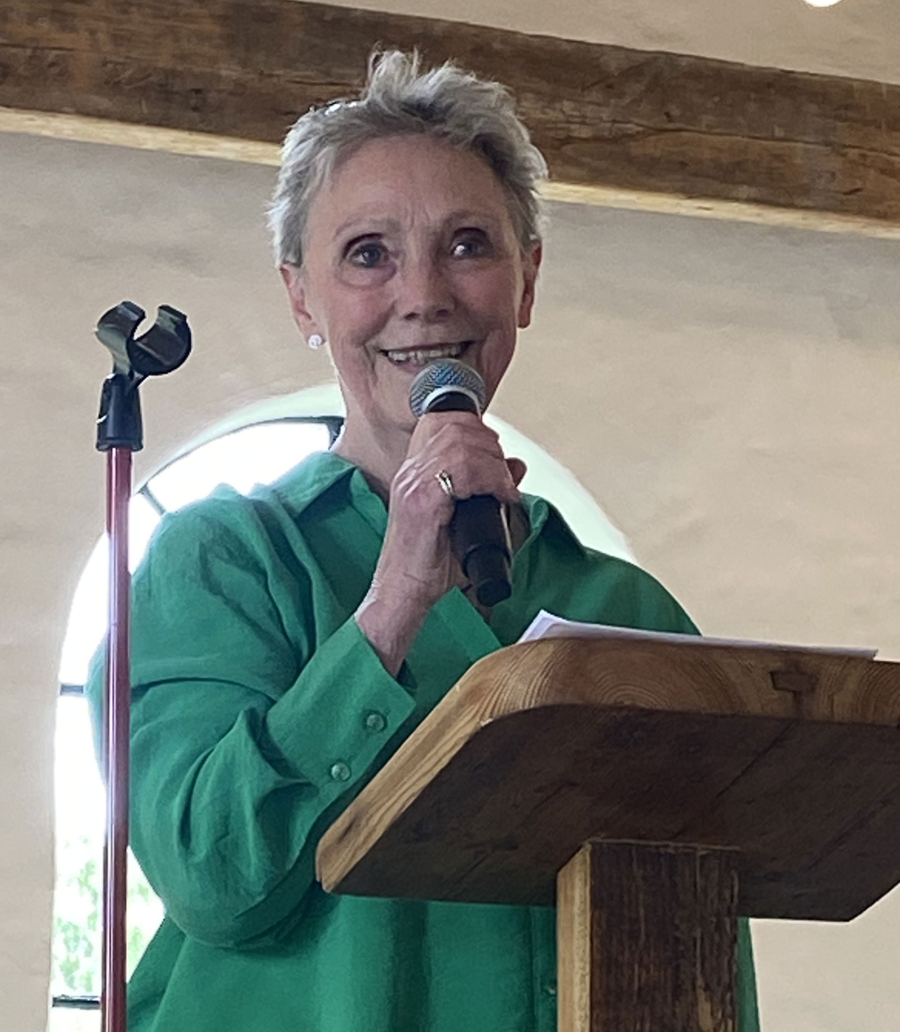 Kvinde står på talerstol og taler i mikrofon