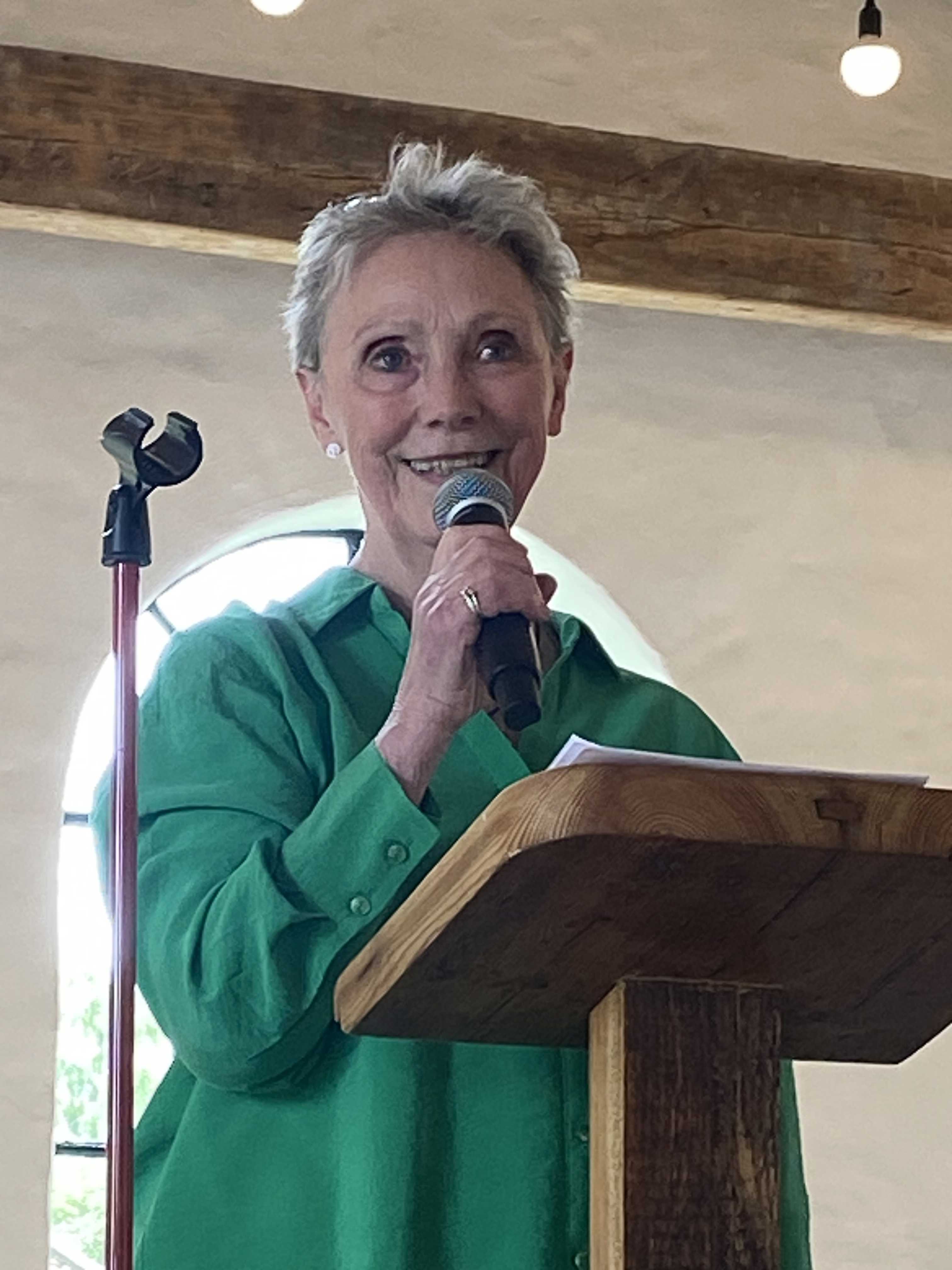 Kvinde står på talerstol og taler i mikrofon