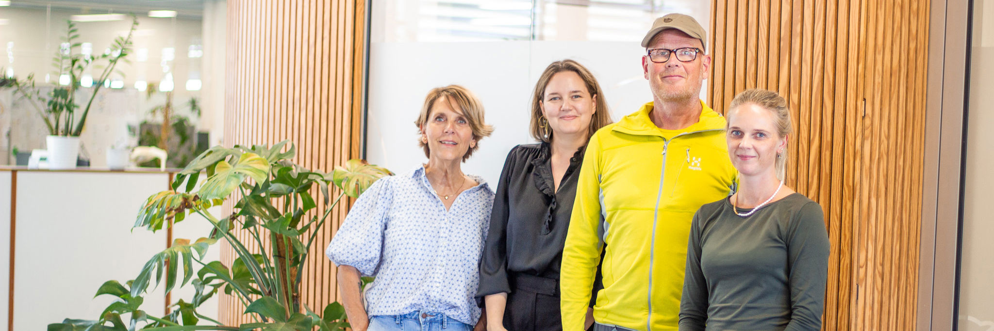 Fire personer foran en væg