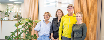 Fire personer foran en væg