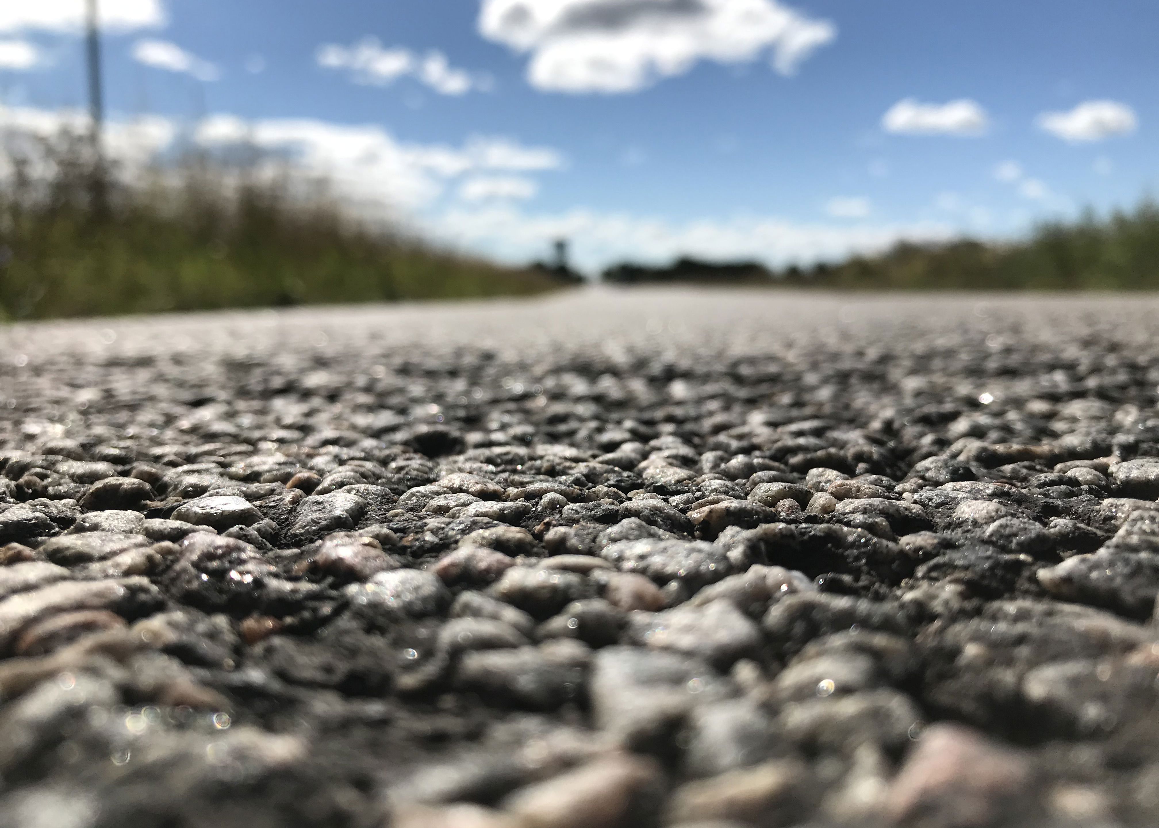 Closeup af en vej hvor man tydeligt ser de småsten en vejbelægning er lavet af
