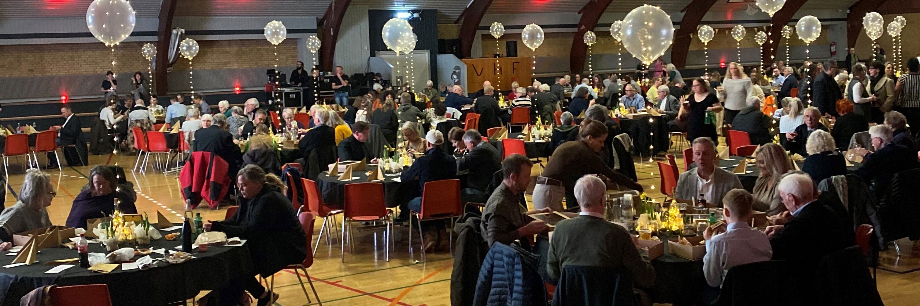 To mennesker sidder ved et skrivebord og taler