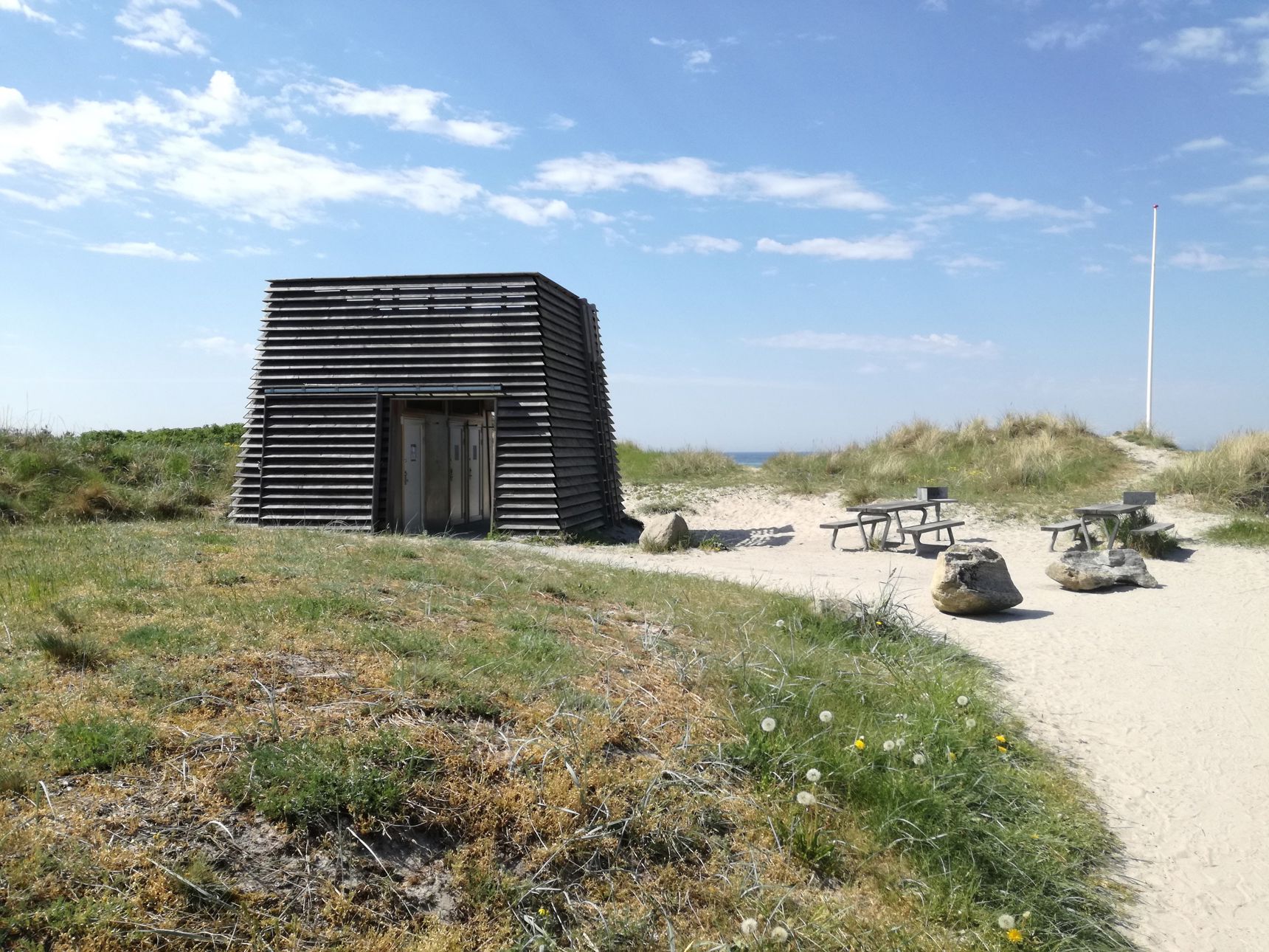 Toiletbygningen på Nordstrandsvej. Der er blå himmel.