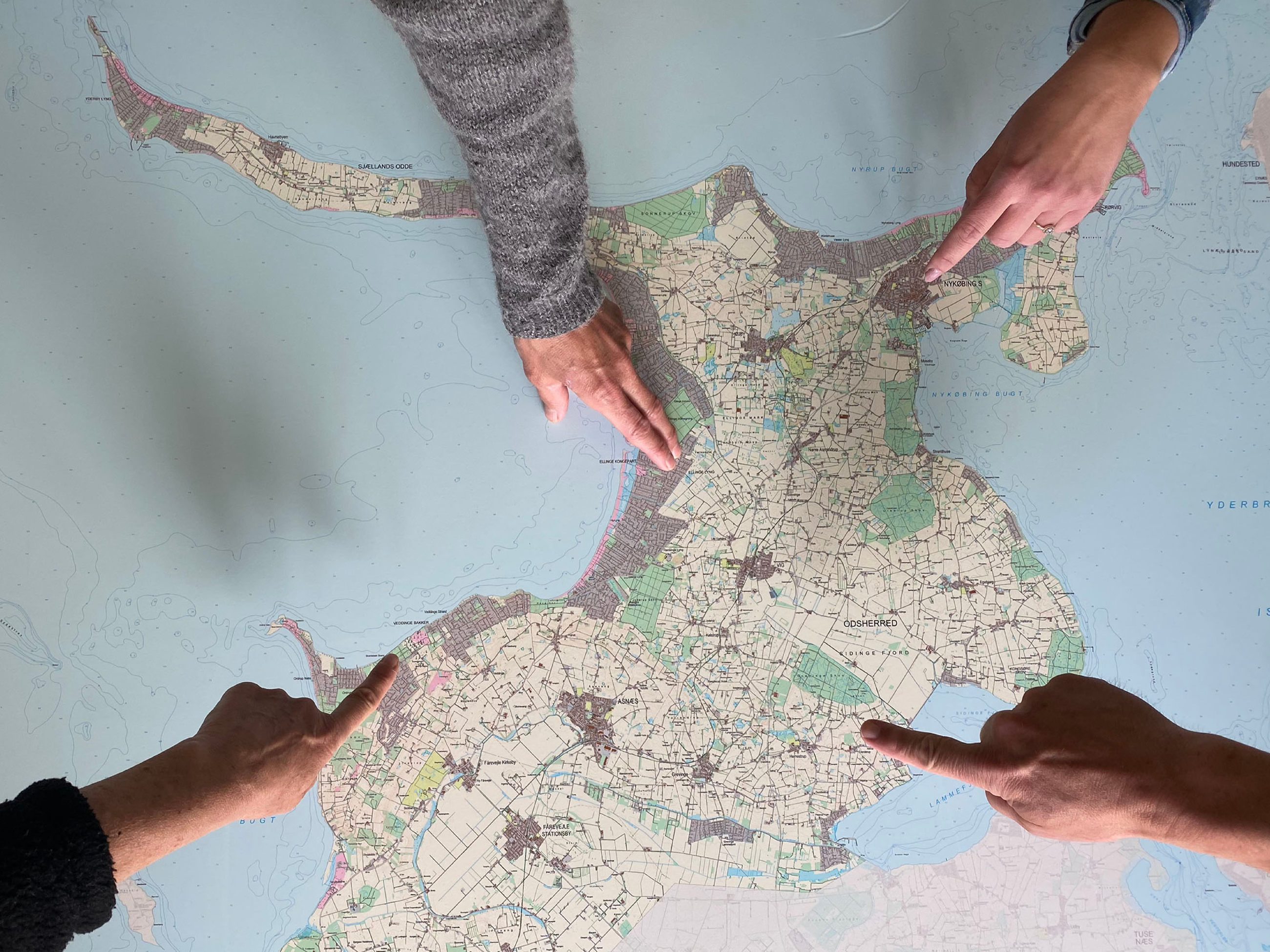 Hænder der peger på et detaljeret landkort over Odsherred