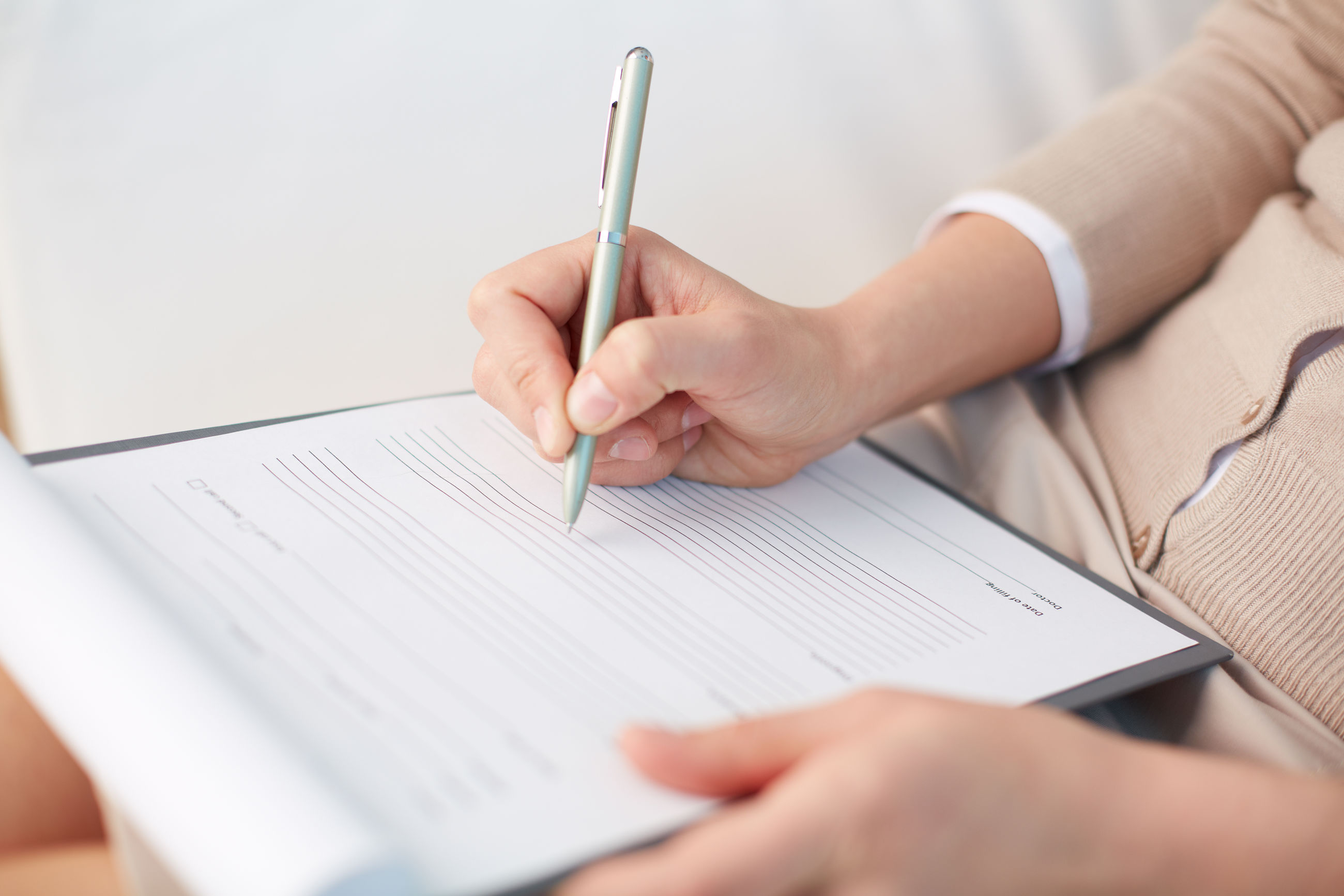 Nærbillede af hænder, der udfylder et spørgeskema