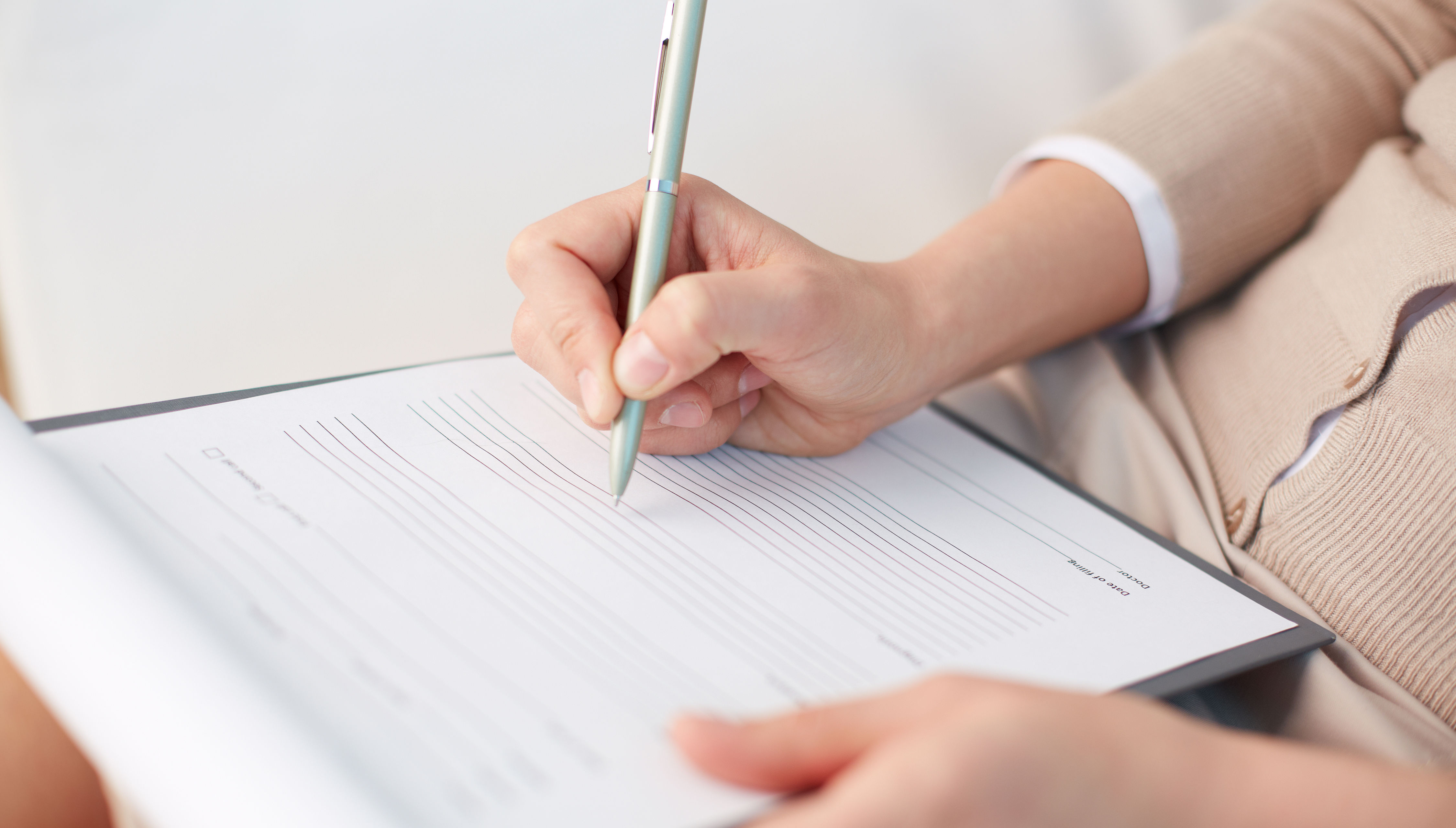 Nærbillede af hænder, der udfylder et spørgeskema