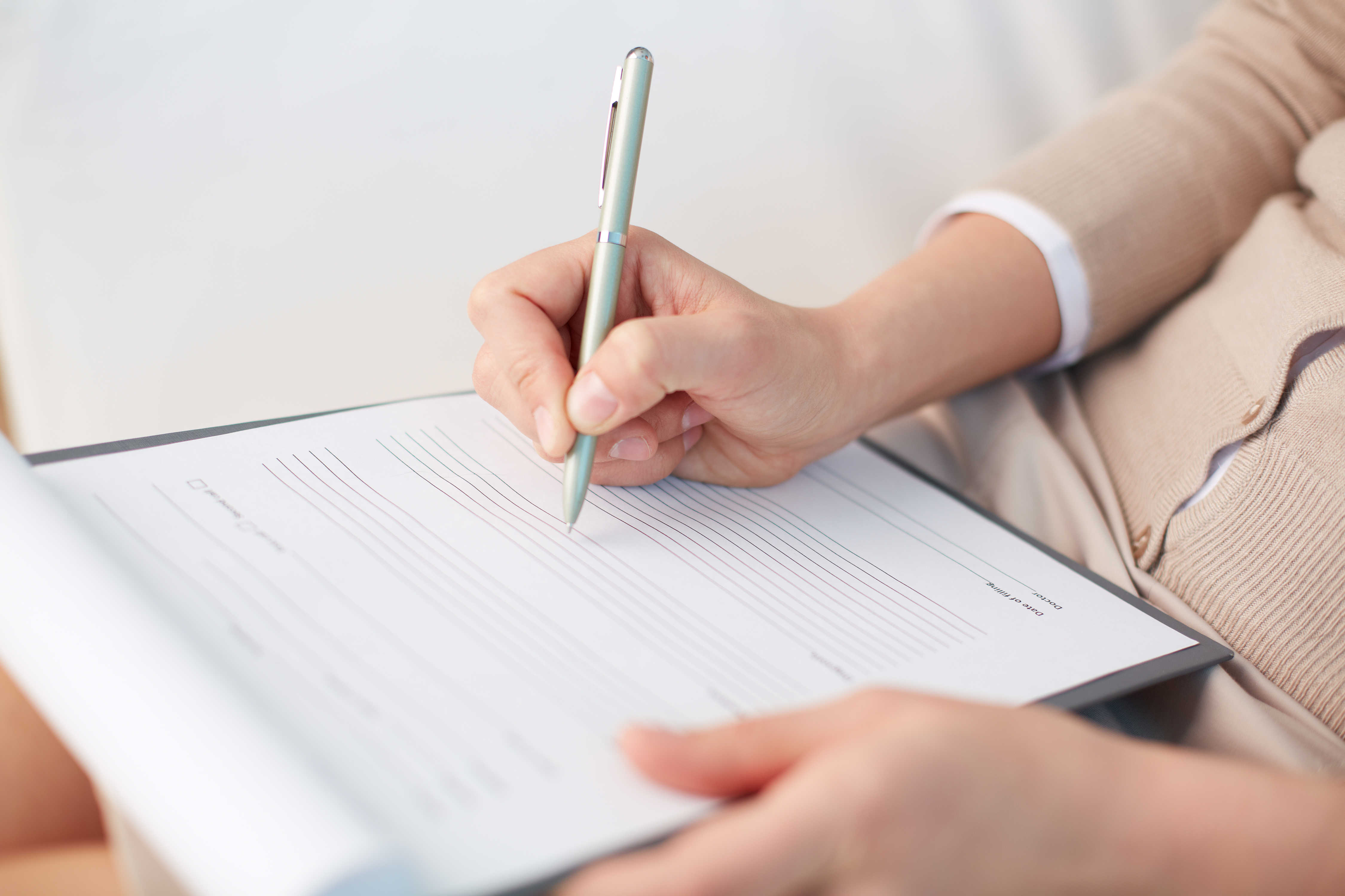 Nærbillede af hænder, der udfylder et spørgeskema