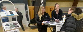 Tre kvinder står ved cafebord og taler sammen