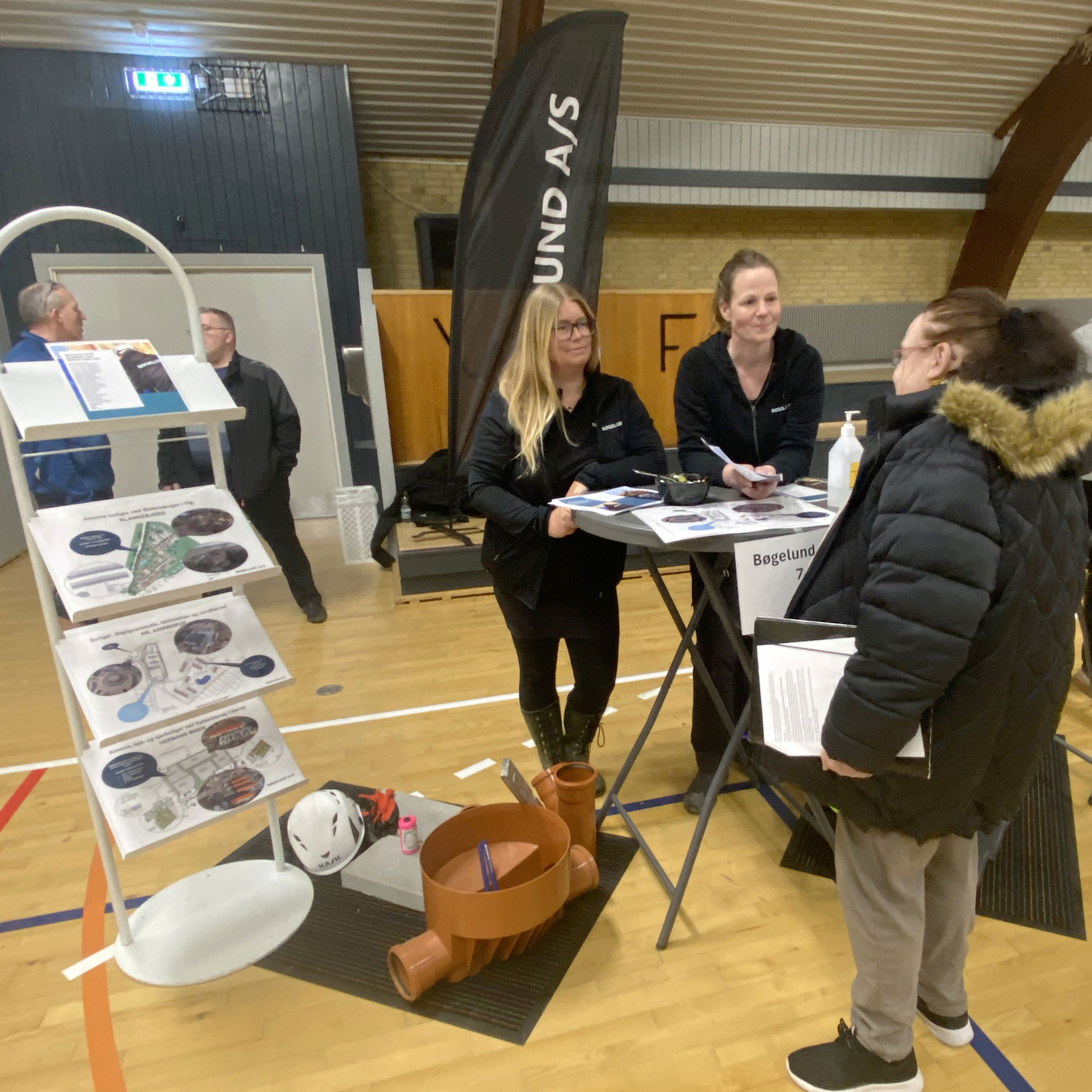 Tre kvinder står ved cafebord og taler sammen