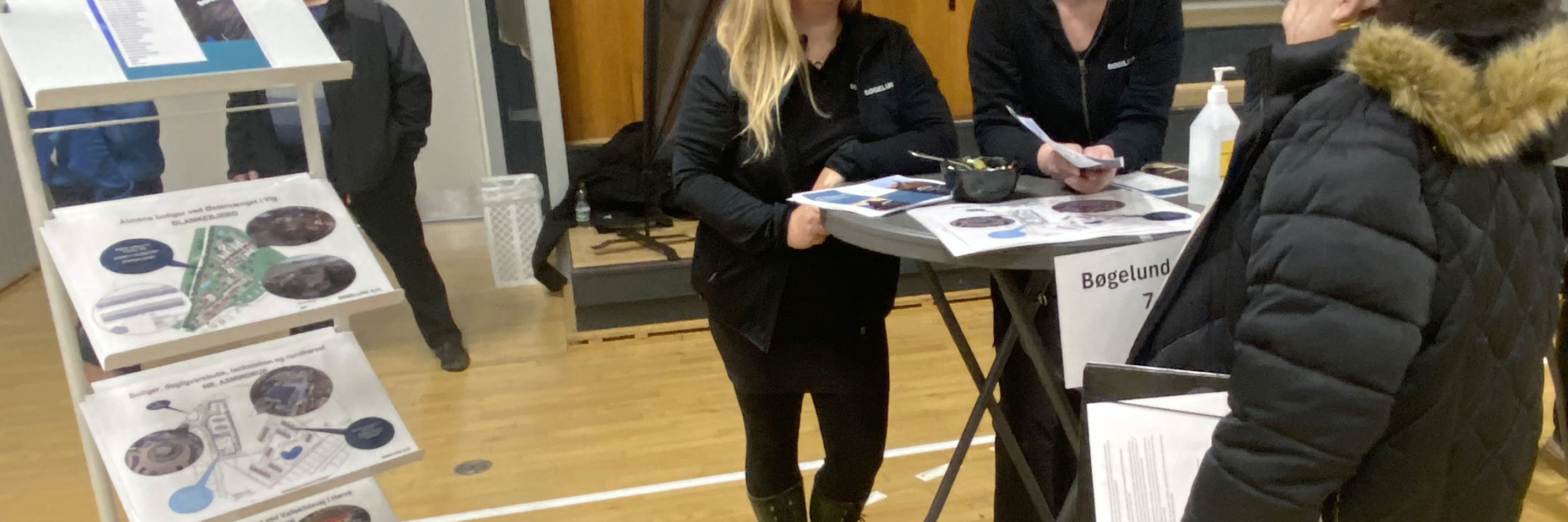 Tre kvinder står ved cafebord og taler sammen