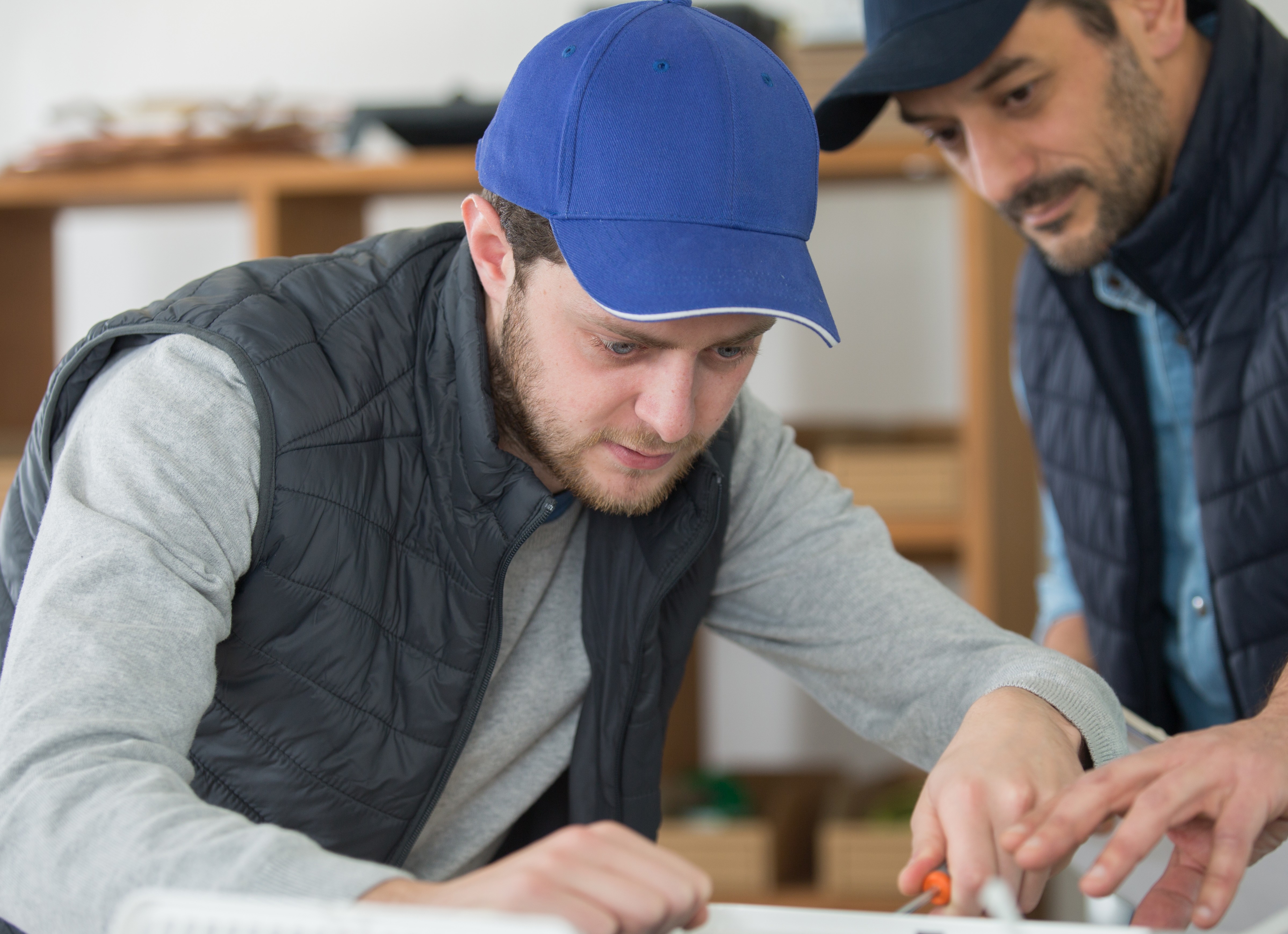 To håndværkere laver en tegning eller opmåling