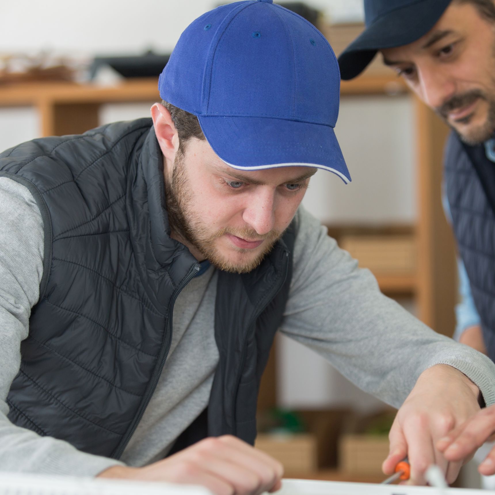 To håndværkere laver en tegning eller opmåling