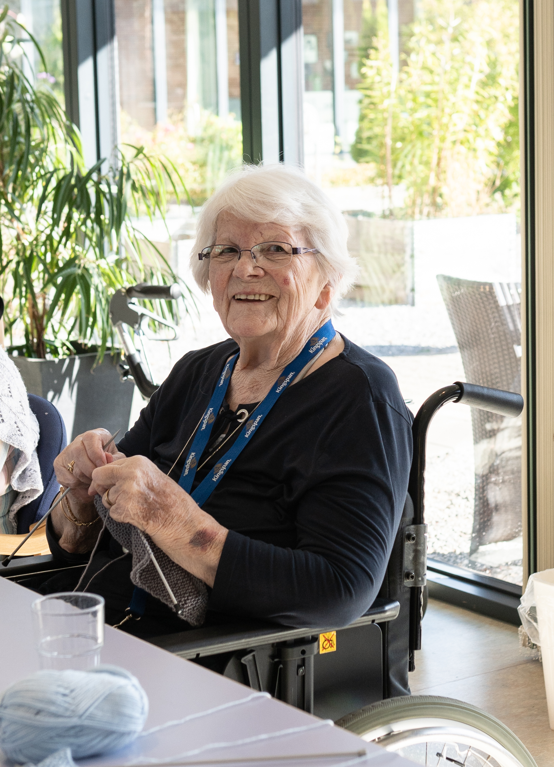 Smilende beboer med sit strikketøj