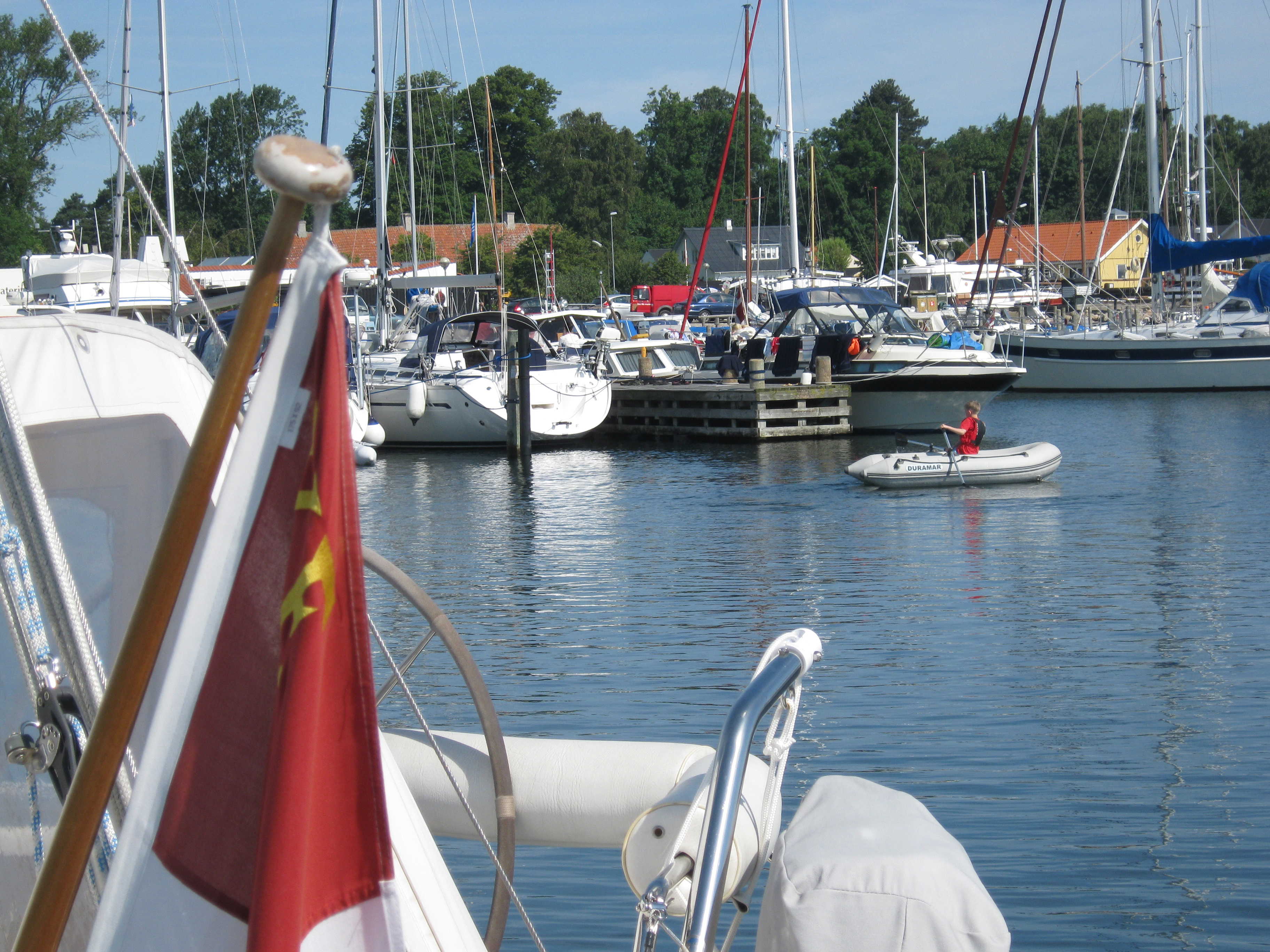Indsejling til lystbådehavnen. I forgrunden både. I baggrunden huse på havnen.