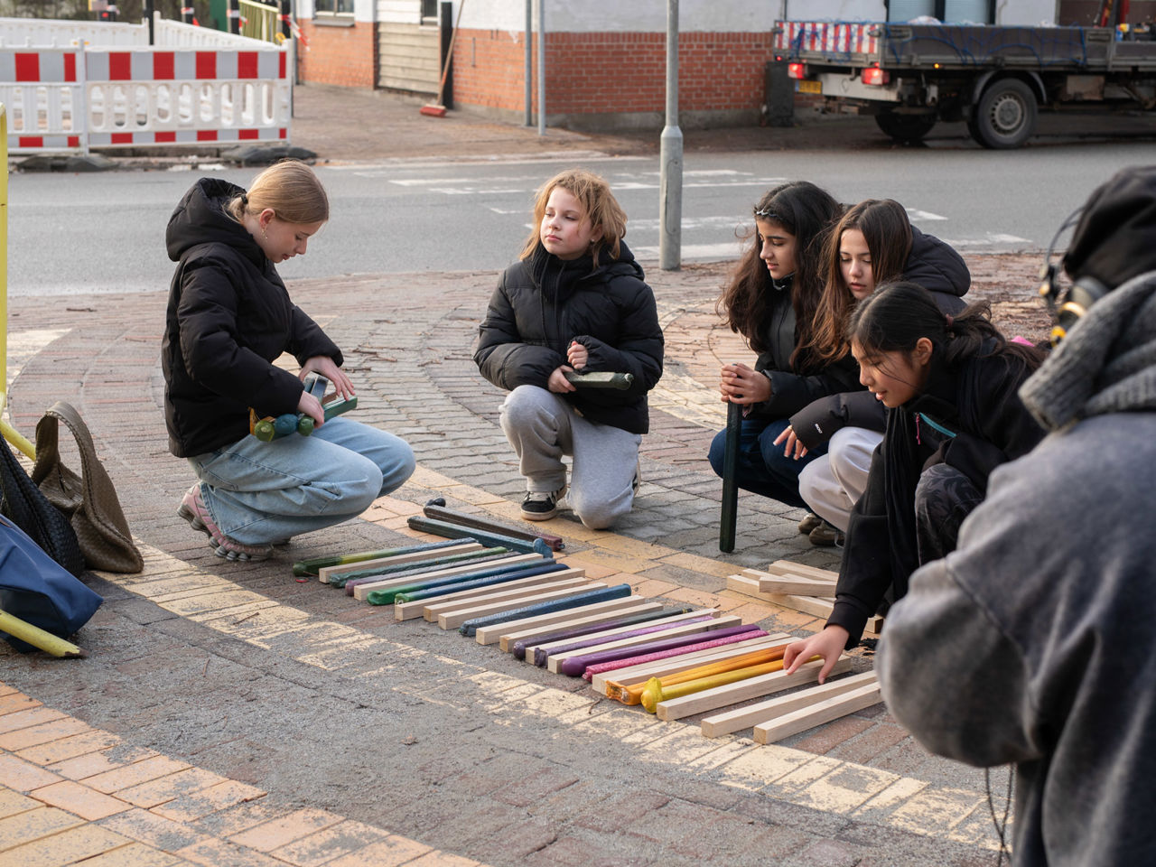 En gruppe skoleelever kigger på materialer til de nye bænke på Asnæs Station