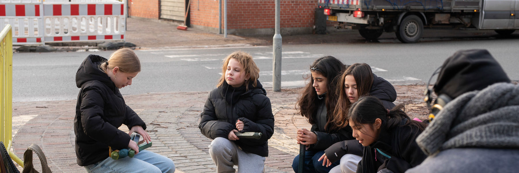 En gruppe skoleelever kigger på materialer til de nye bænke på Asnæs Station