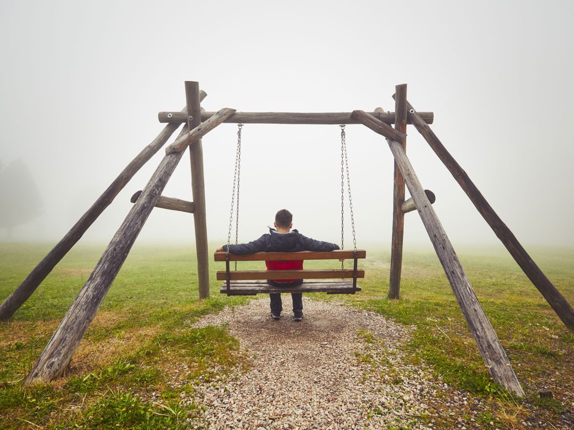 Mand alene på gynge - en tåget dag. Ensomhed