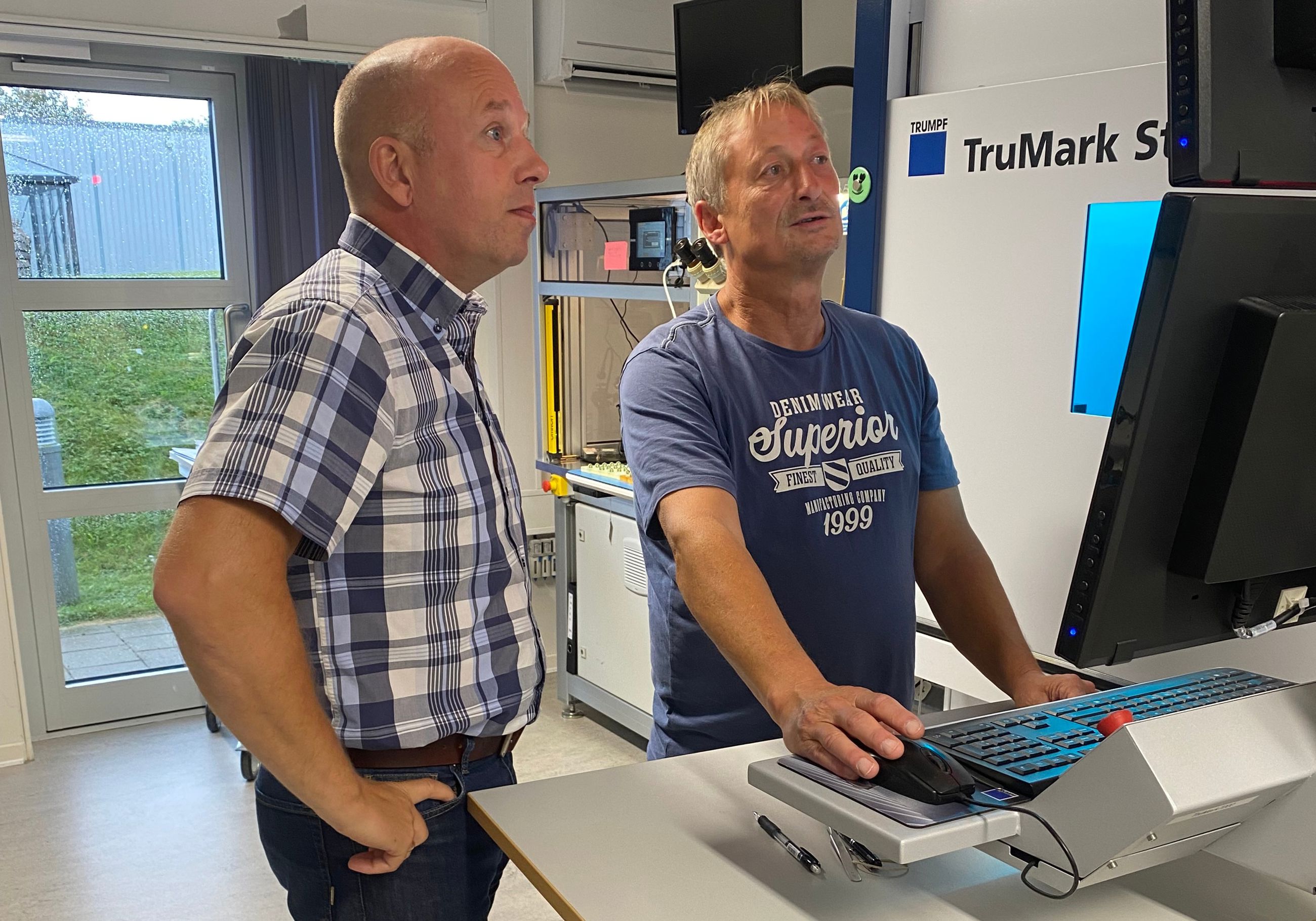 Morten Rubæk og en medarbejder kigger på en computerskærm