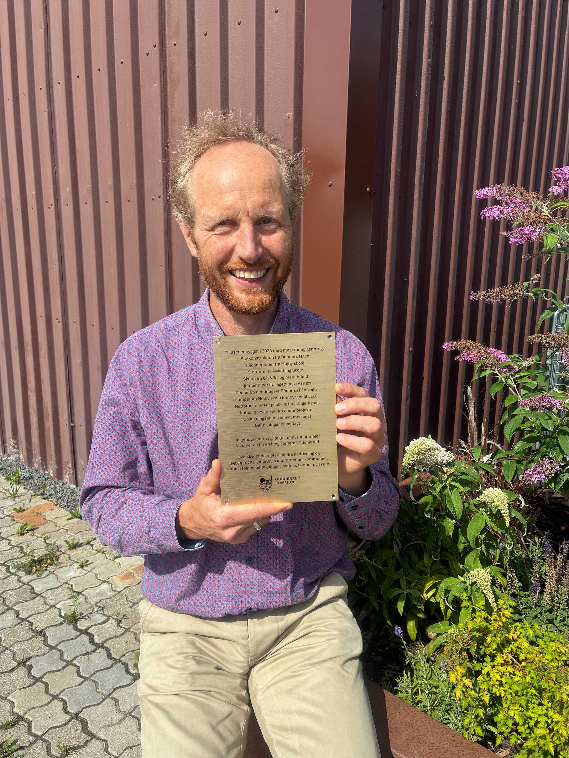 Mand står med en plakette