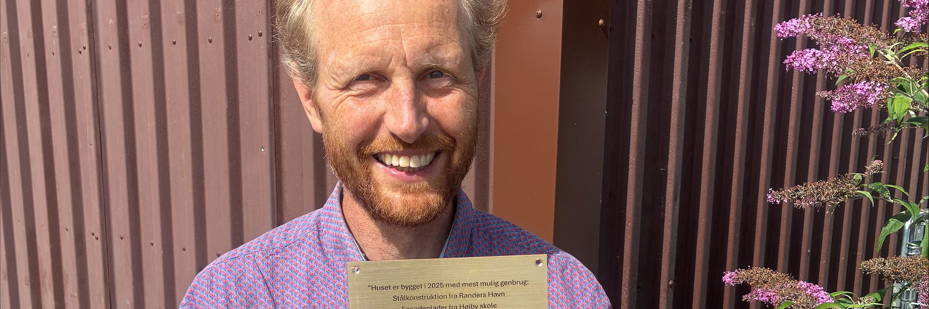 Mand står med en plakette