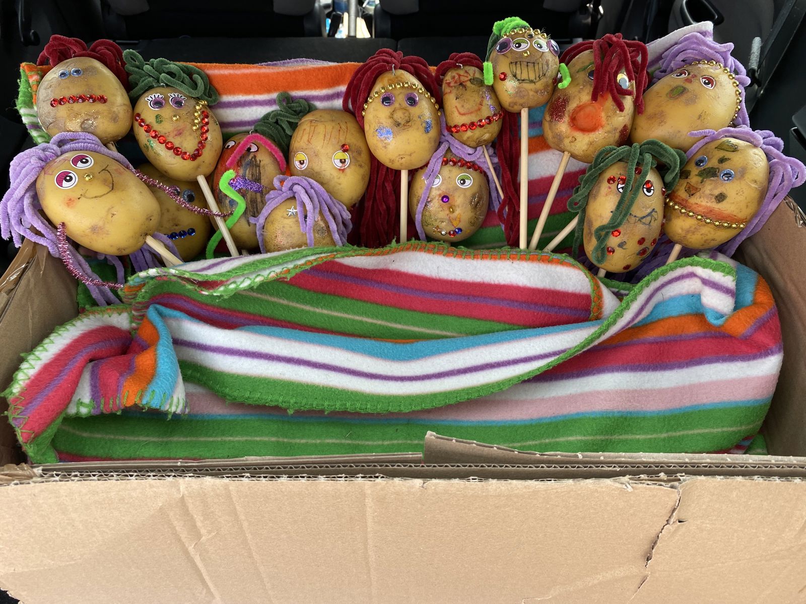 Kasse med sjove, pyntede kartofler