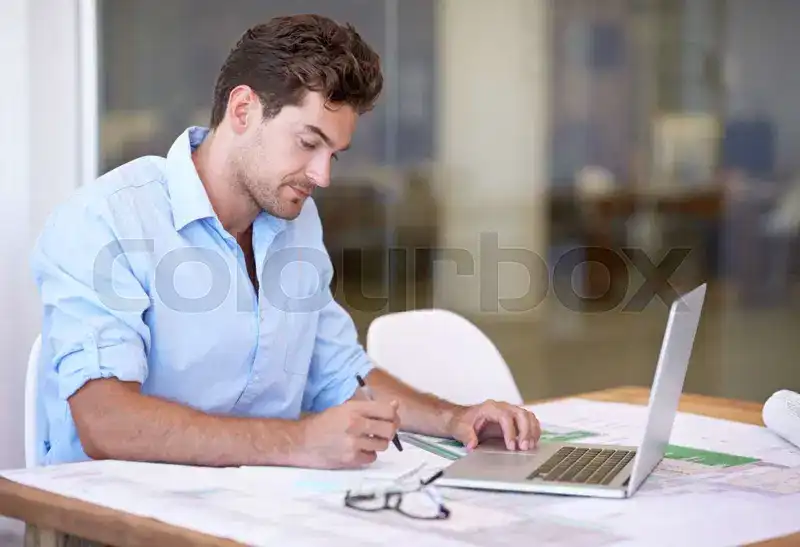 Mand med computer og tegninger