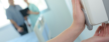 Hænder der tager håndsprit fra automat