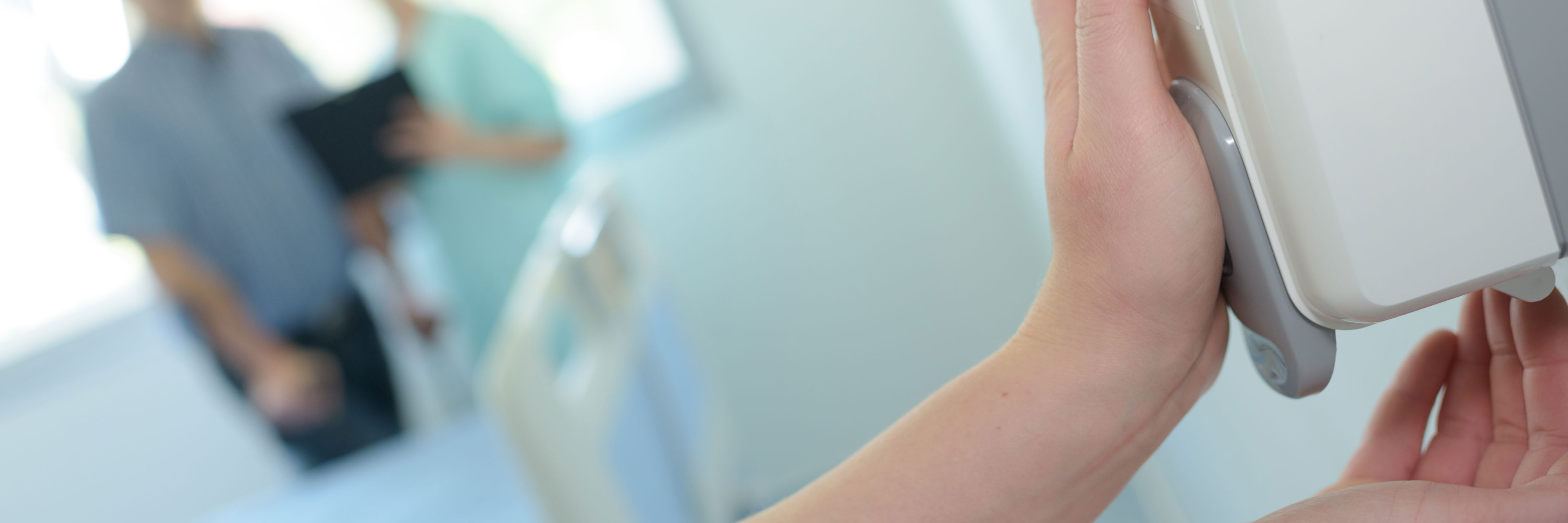 Hænder der tager håndsprit fra automat