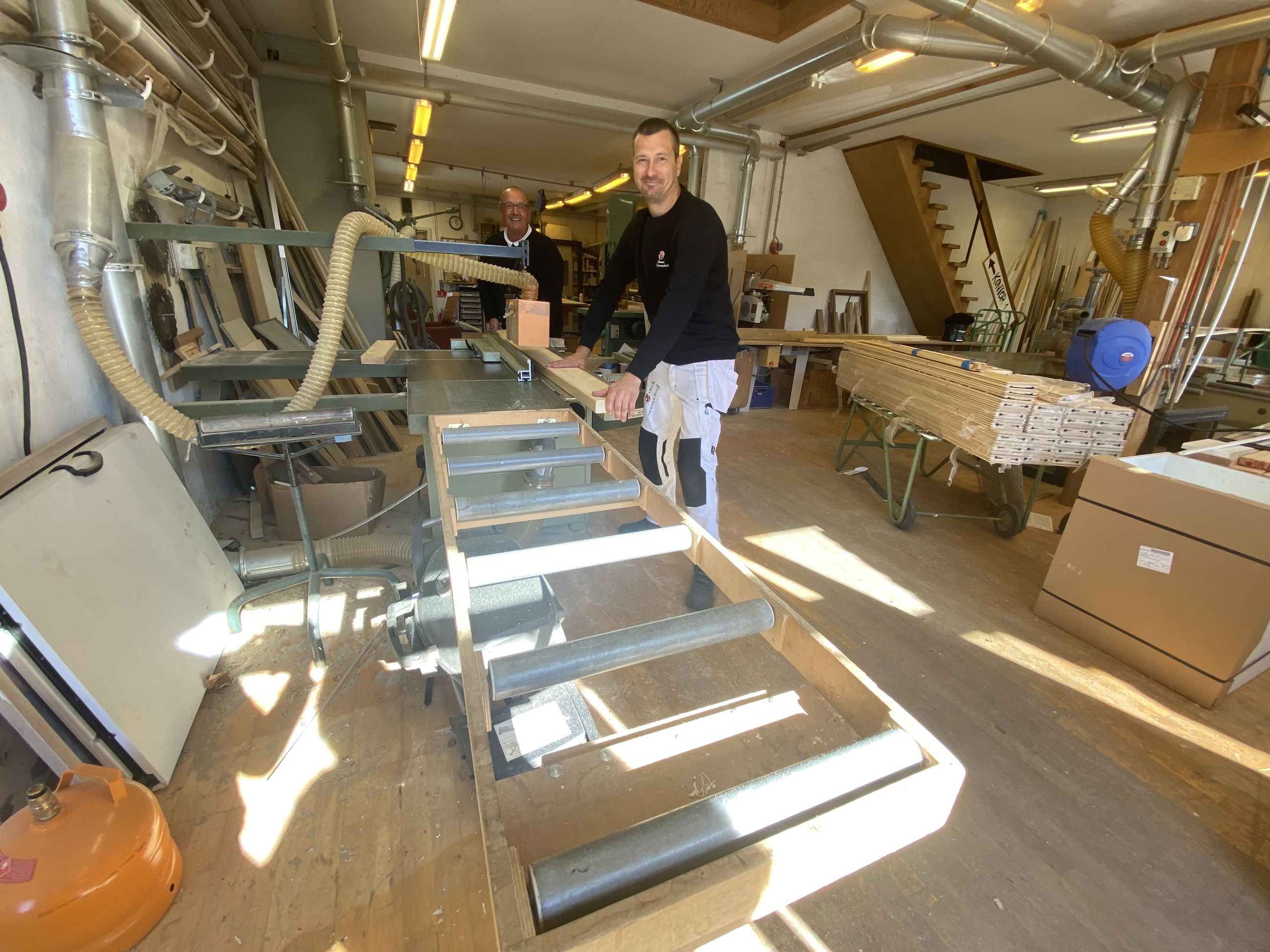 To mennesker arbejder i maskinsnedkeri.