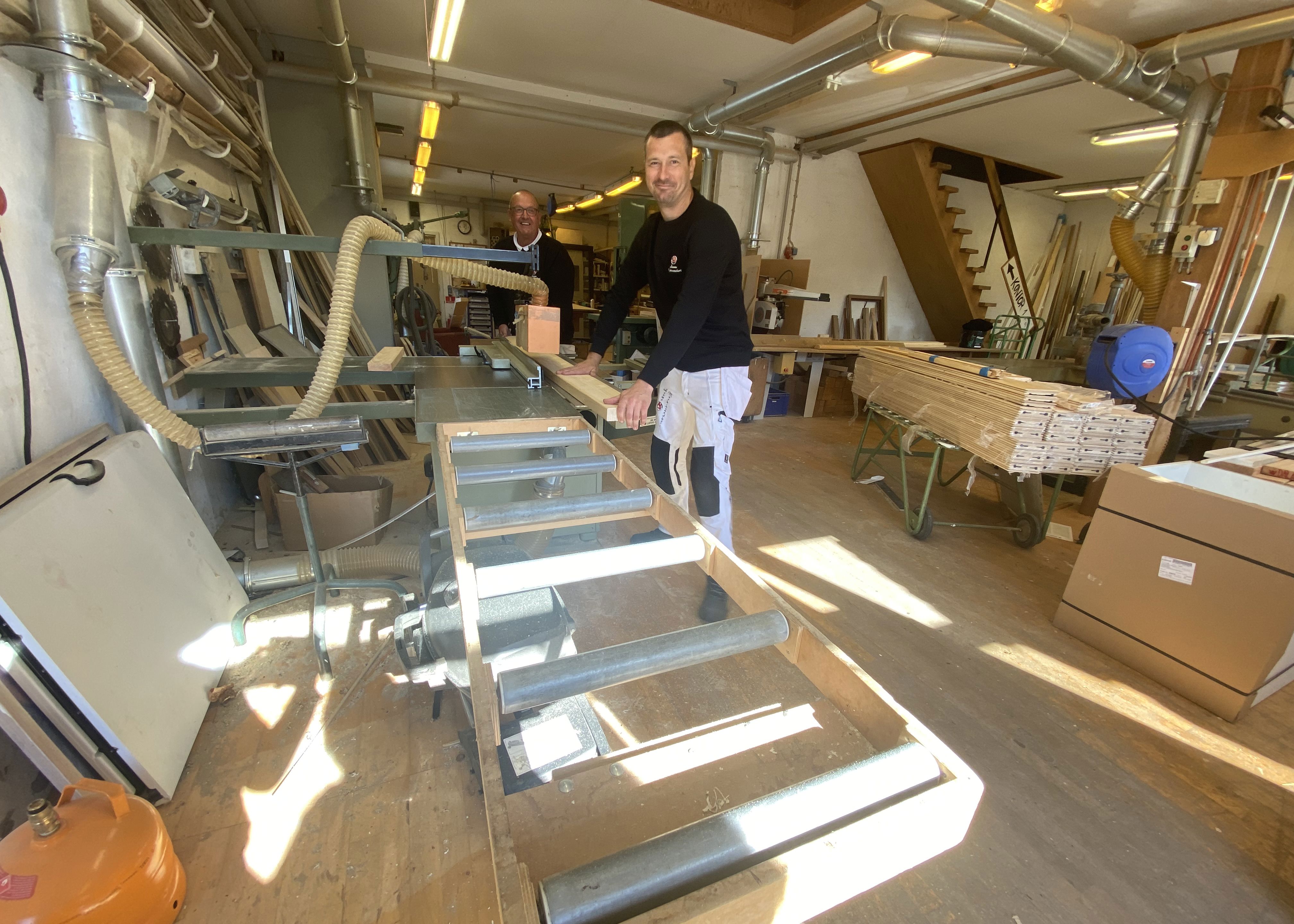 To mennesker arbejder i maskinsnedkeri.