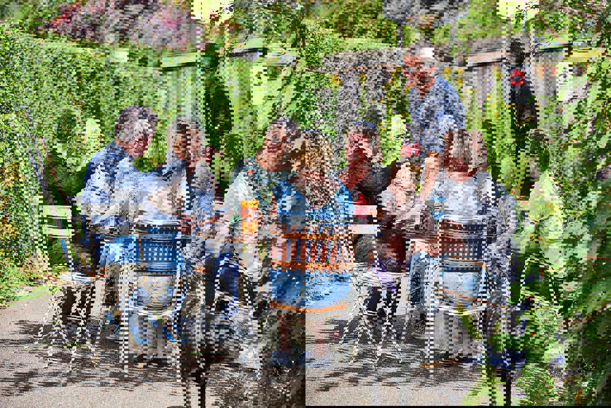 Mennesker der sidder ved et havebord