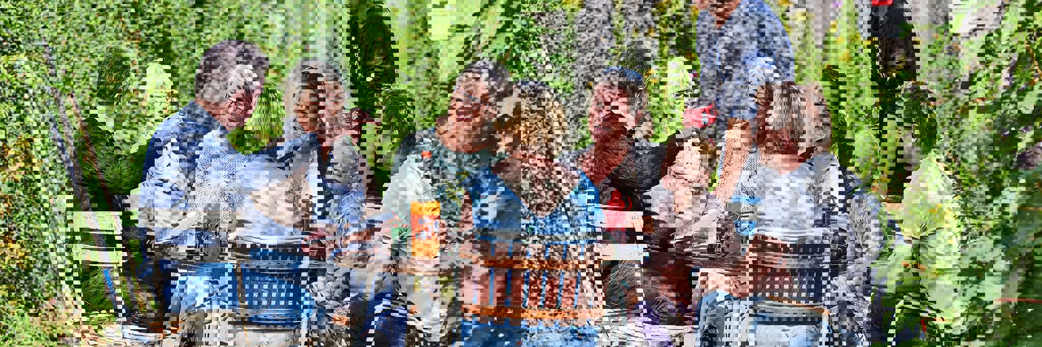 Mennesker der sidder ved et havebord