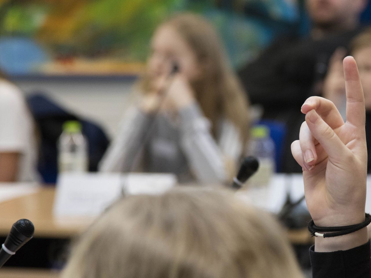 ET barn rækker hånden op foran en mikrofon