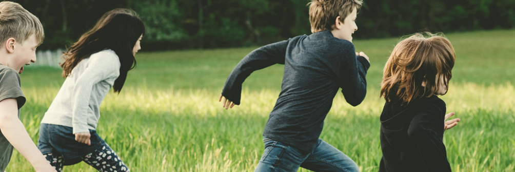 Børn der leger på en eng