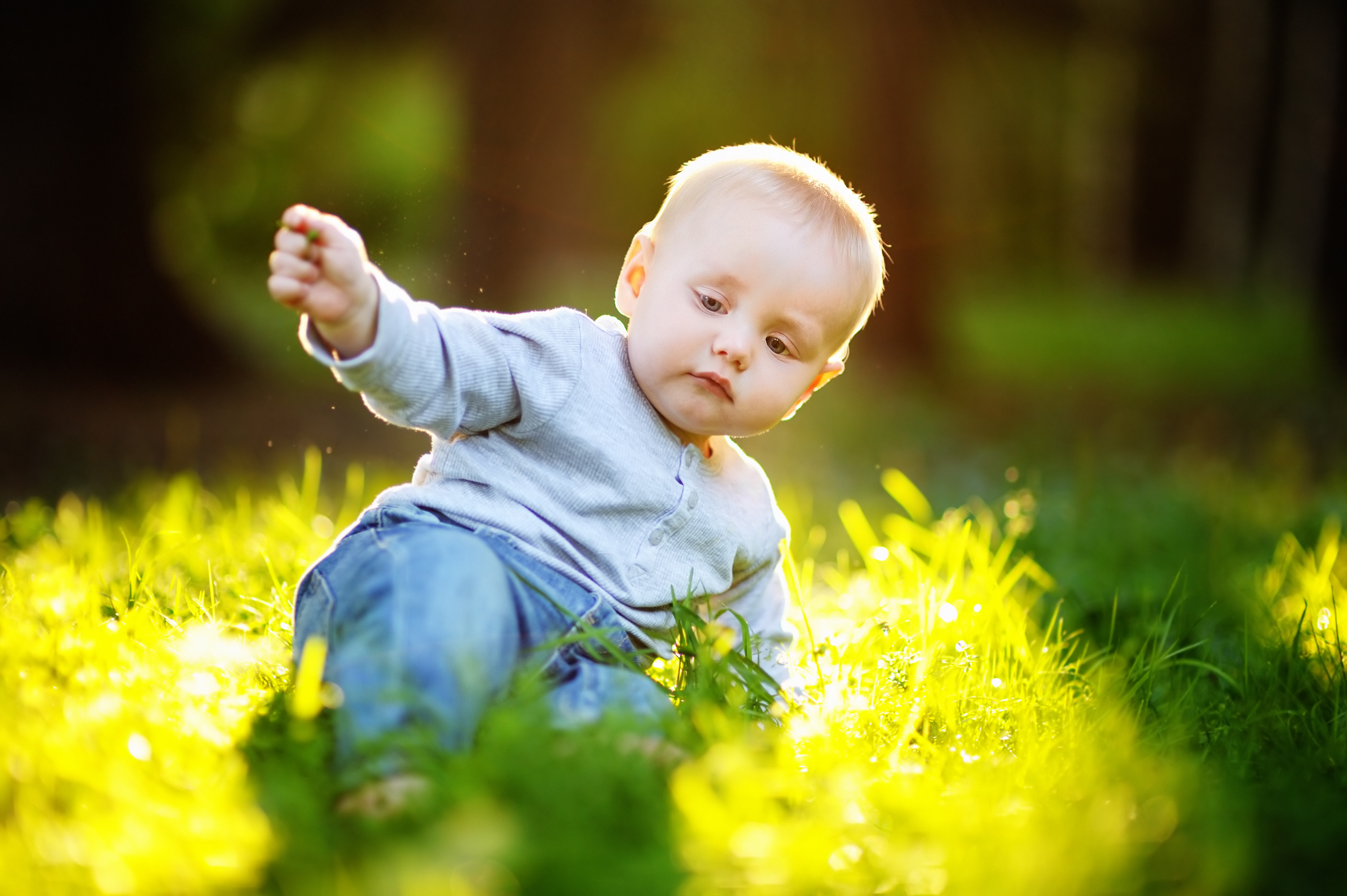 Baby der leger i græsset