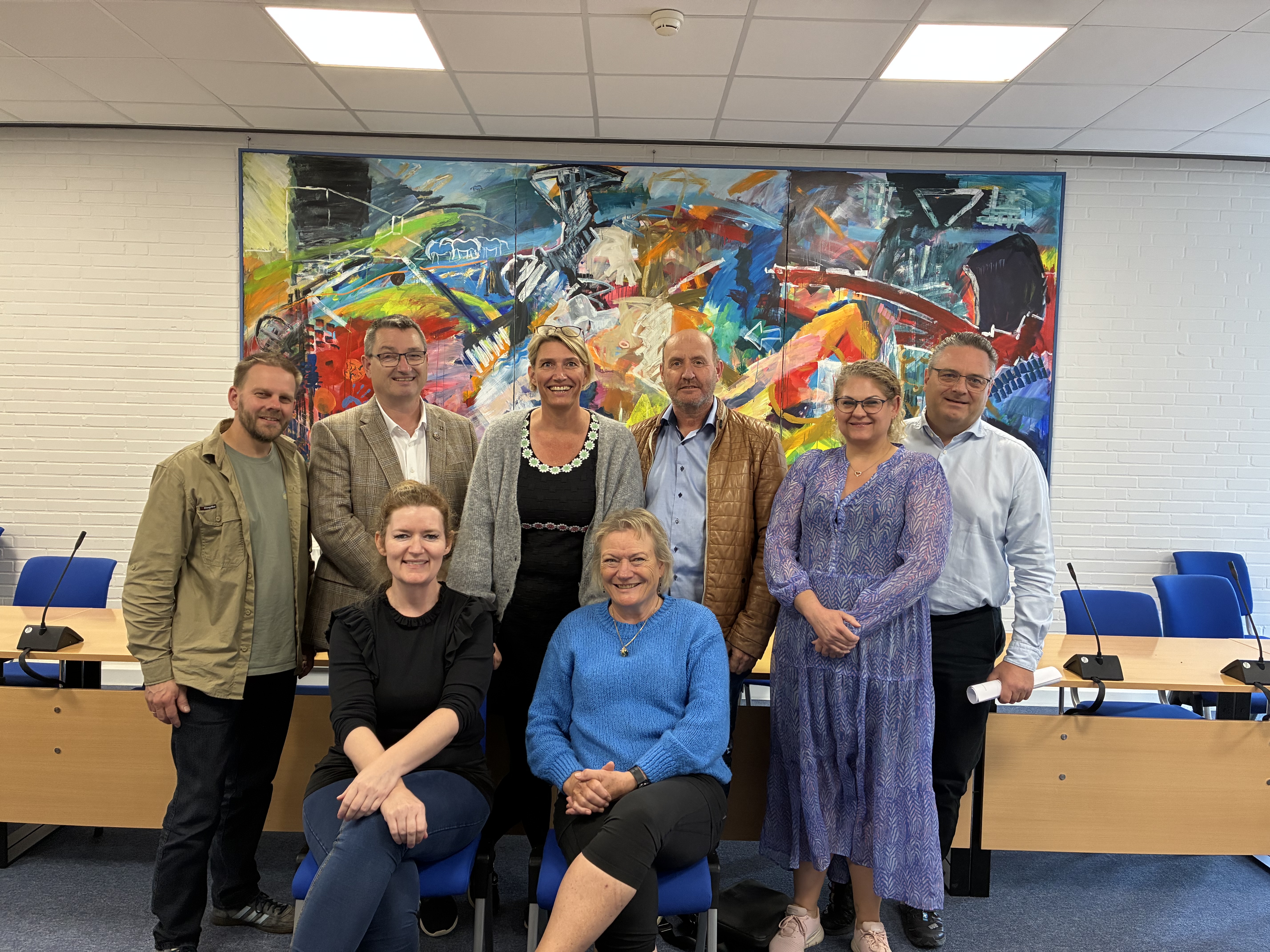 Gruppebillede af glade byrådspolitikere efter underskrift på budgetaftale