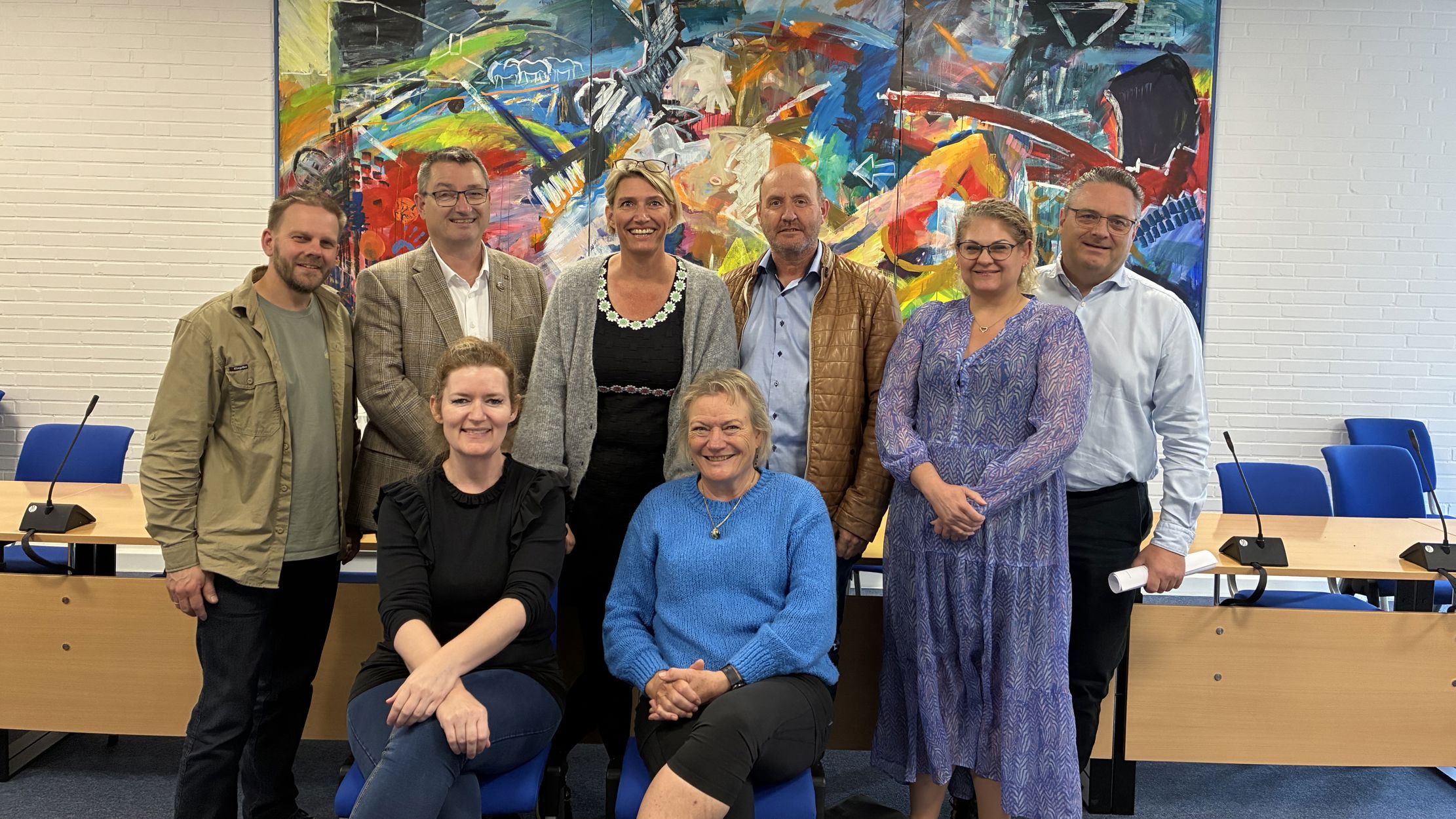 Gruppebillede af glade byrådspolitikere efter underskrift på budgetaftale