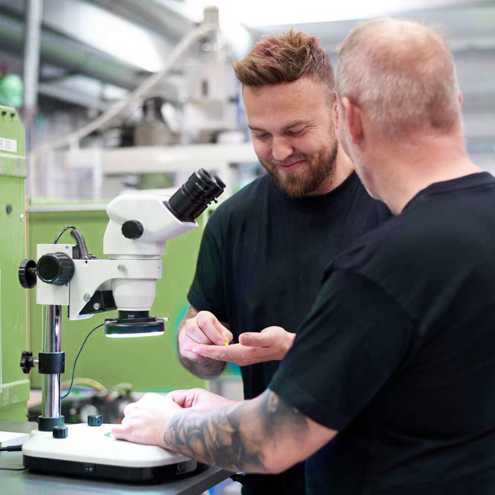 To medarbejdere ved et mikroskop