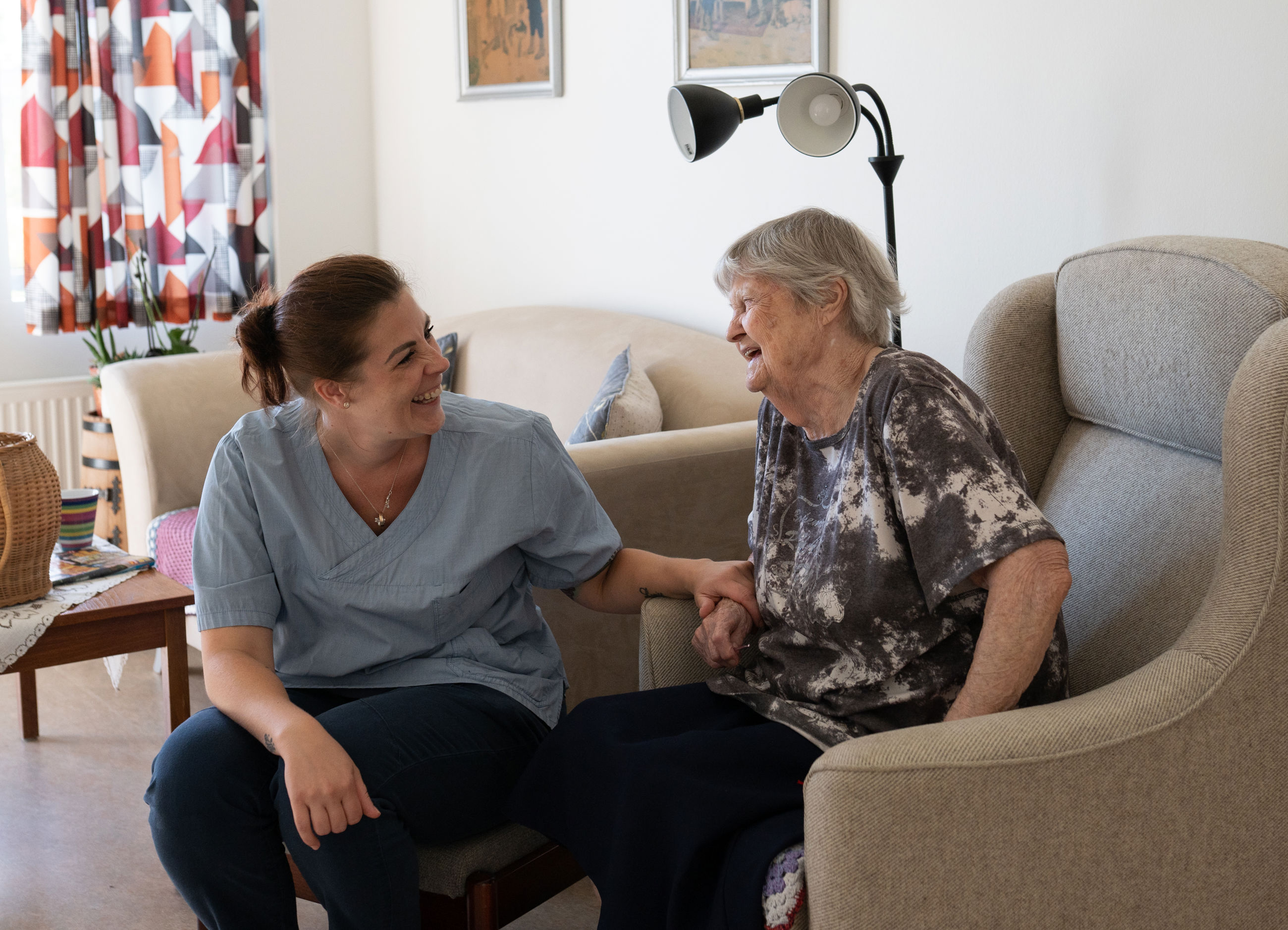 Medarbejder og beboer griner sammen