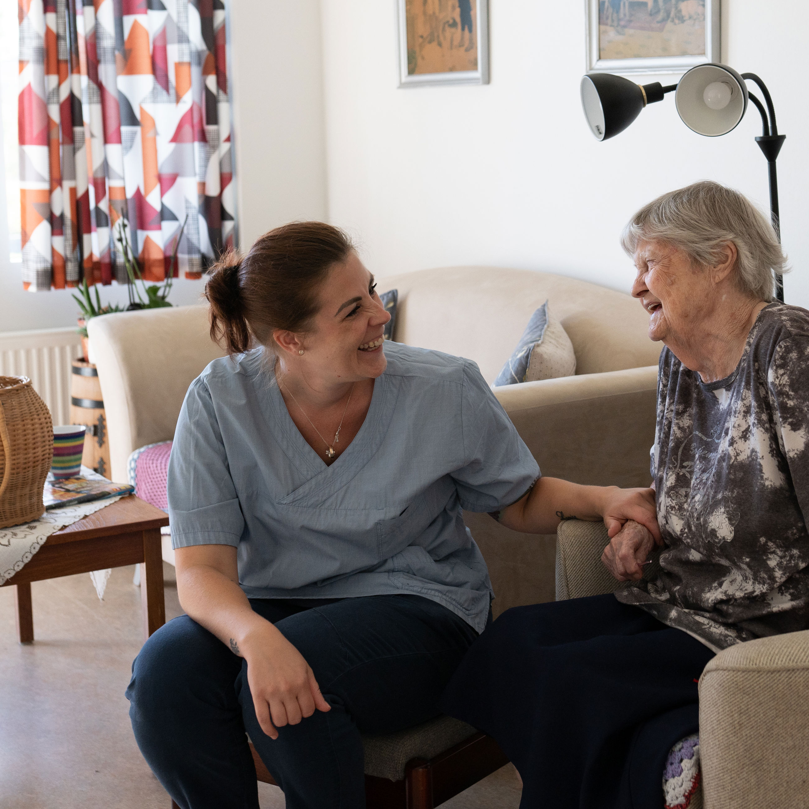 Medarbejder og beboer griner sammen