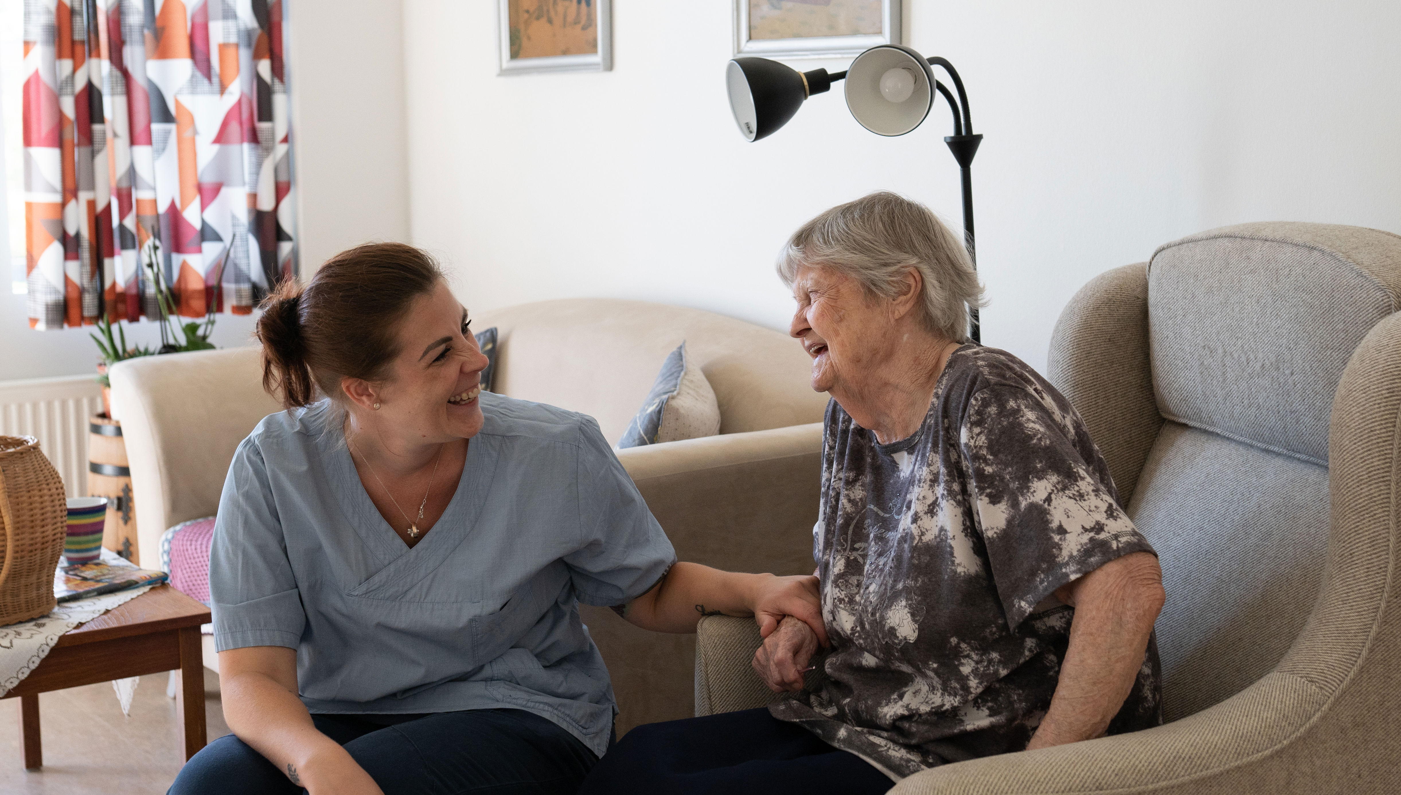 Medarbejder og beboer griner sammen