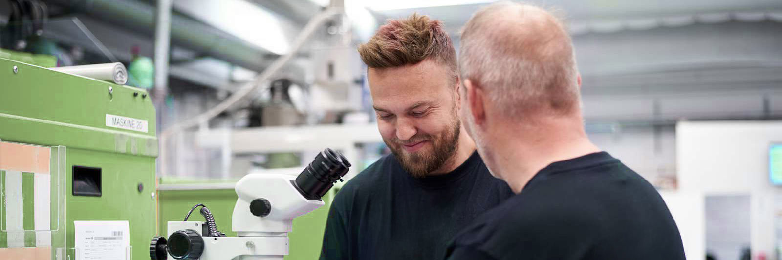 To mænd står ved mikroskop